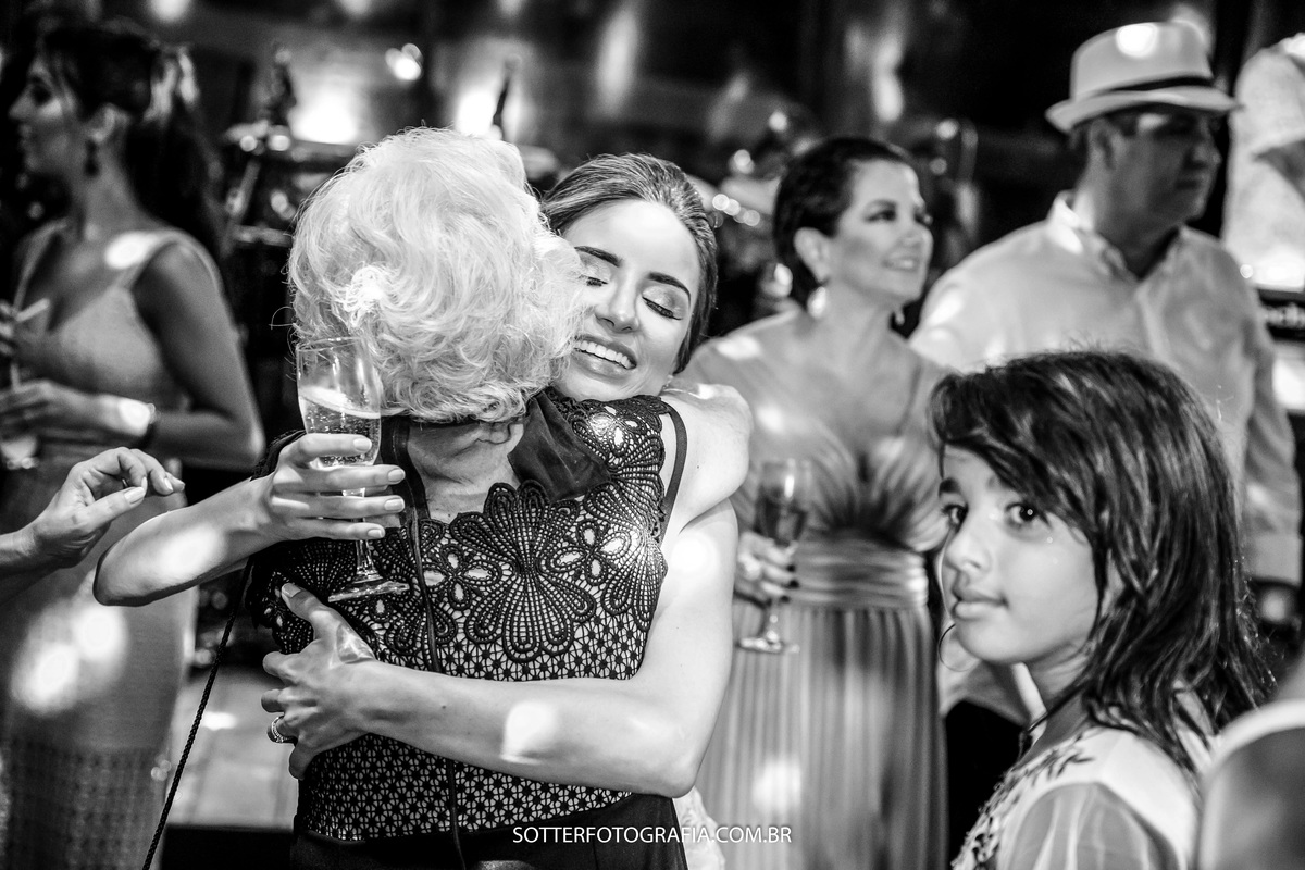 senhora desejando felicidades para a noiva em um abraço forte 