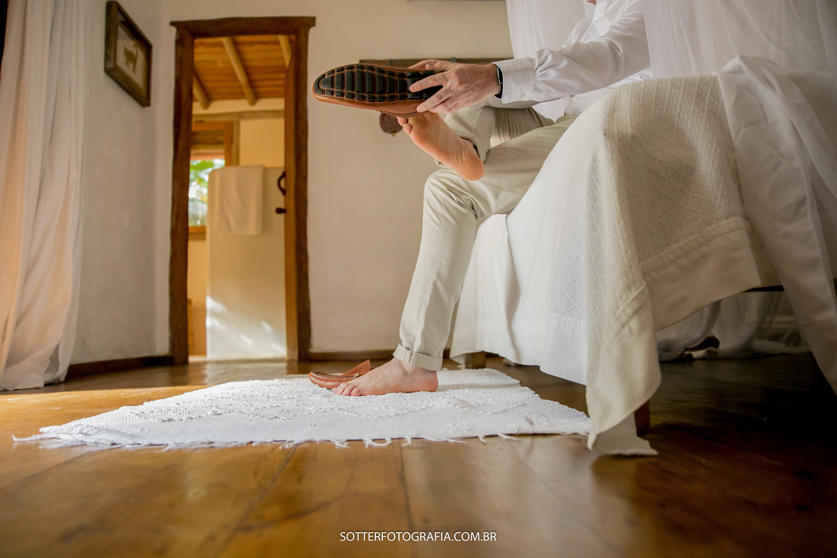 noivo em quarto de pousada se arrumando para casamento em trancoso sotter fotografia
