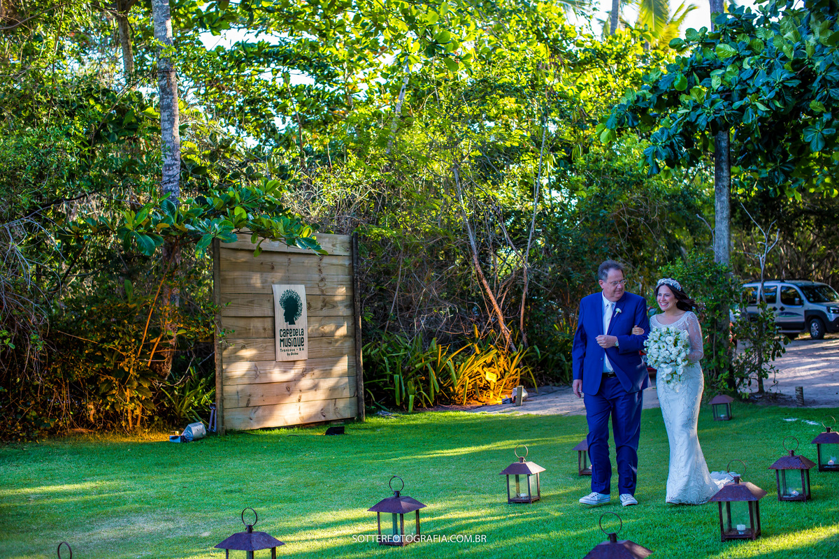 noiva entrando com o pai por um gramado lindo cheio de caixas de luzes no chão