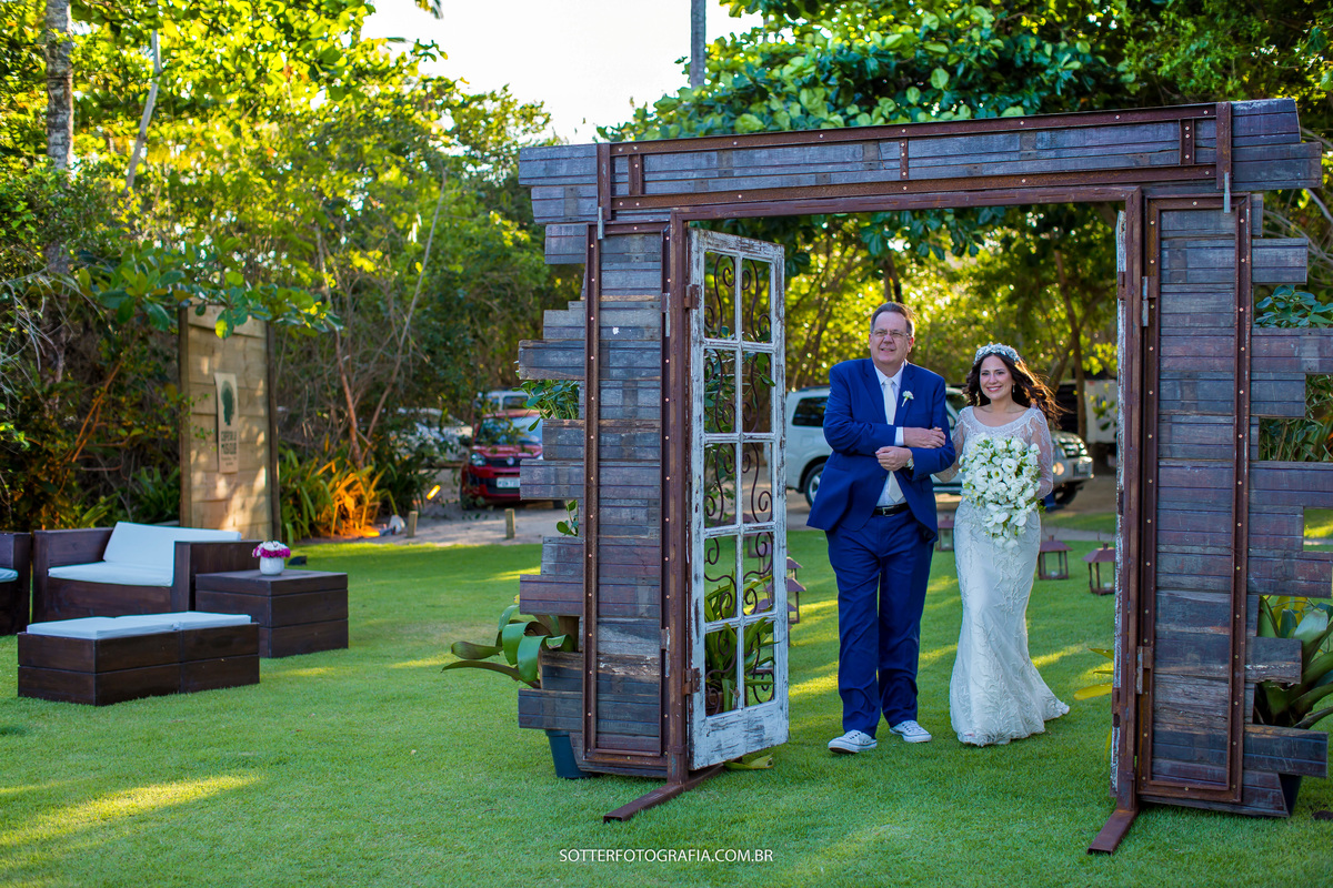 noiva passando com o pai pelo portal que a defleur decoracoes fez