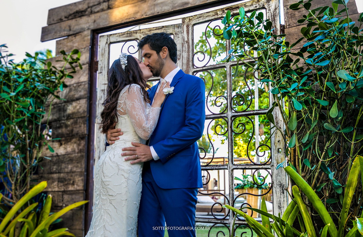 noivos se beijando no portal de madeira