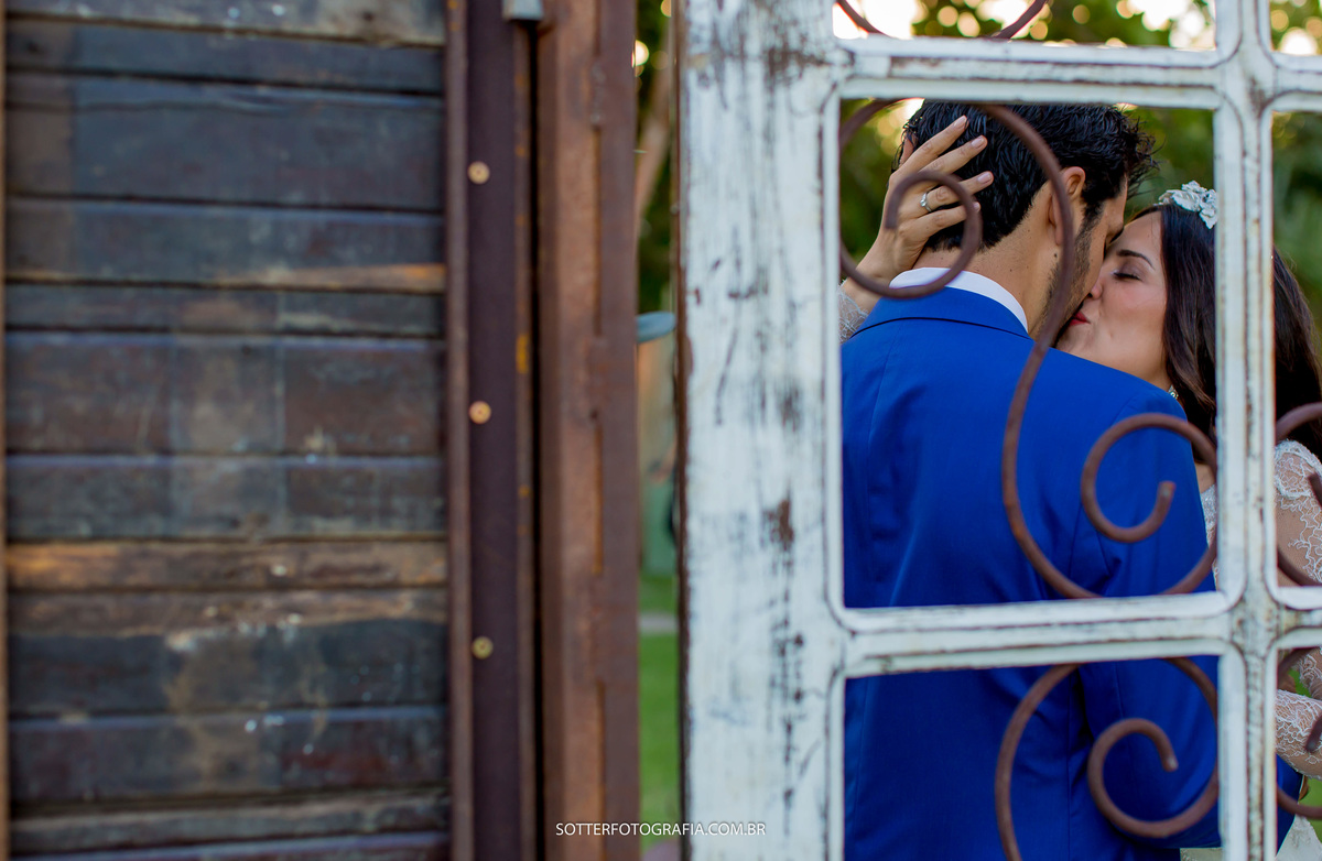 nesta imagem a sotter fotografia ficou escondida atras da porta e pegou o momento exato do beijo dos noivos 
