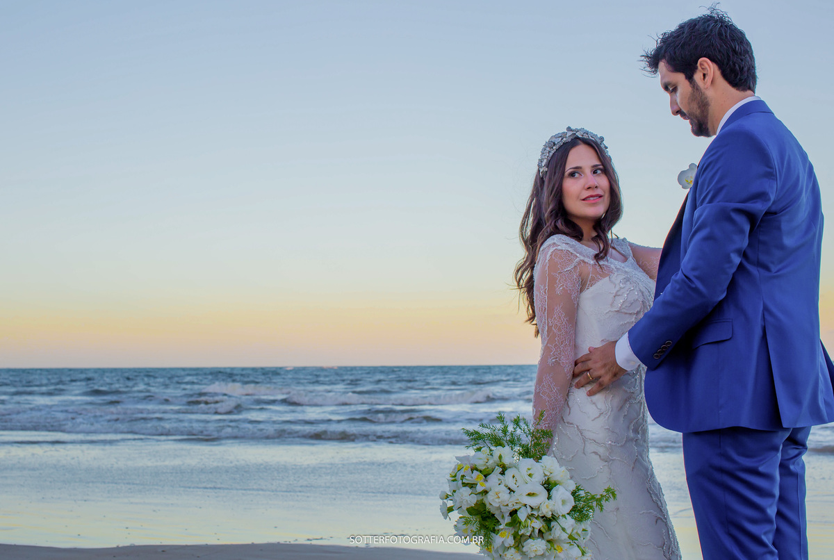 noiva segurando o buque e apoiando a mao no peito do noivo praia linda ao fundo em trancoso