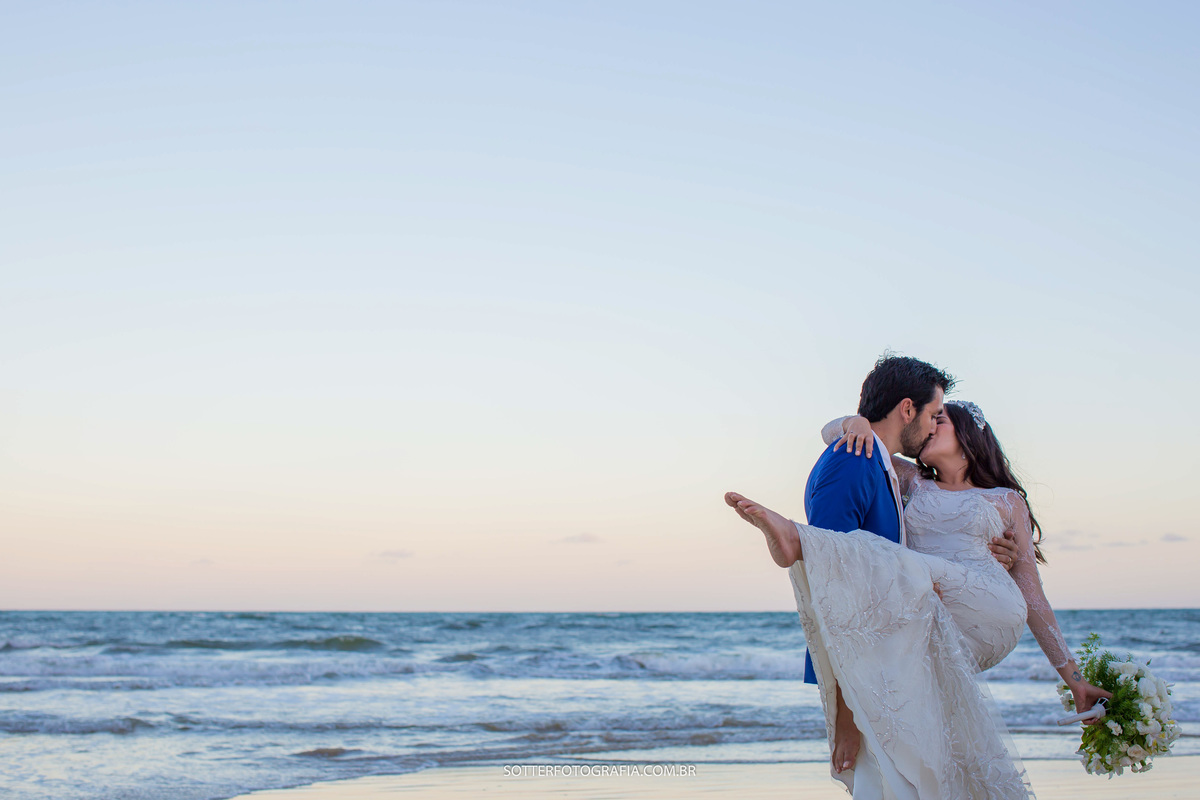 O noivo segurou a noiva no colo para poder beija la na praia de trancoso 