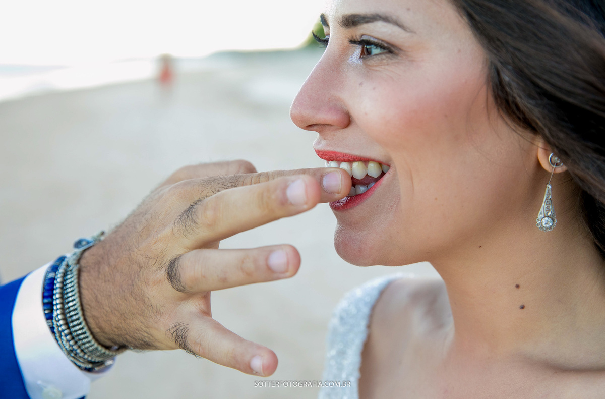 noivo passando o dedo nos dentes da noiva para limpar o batom que sujou