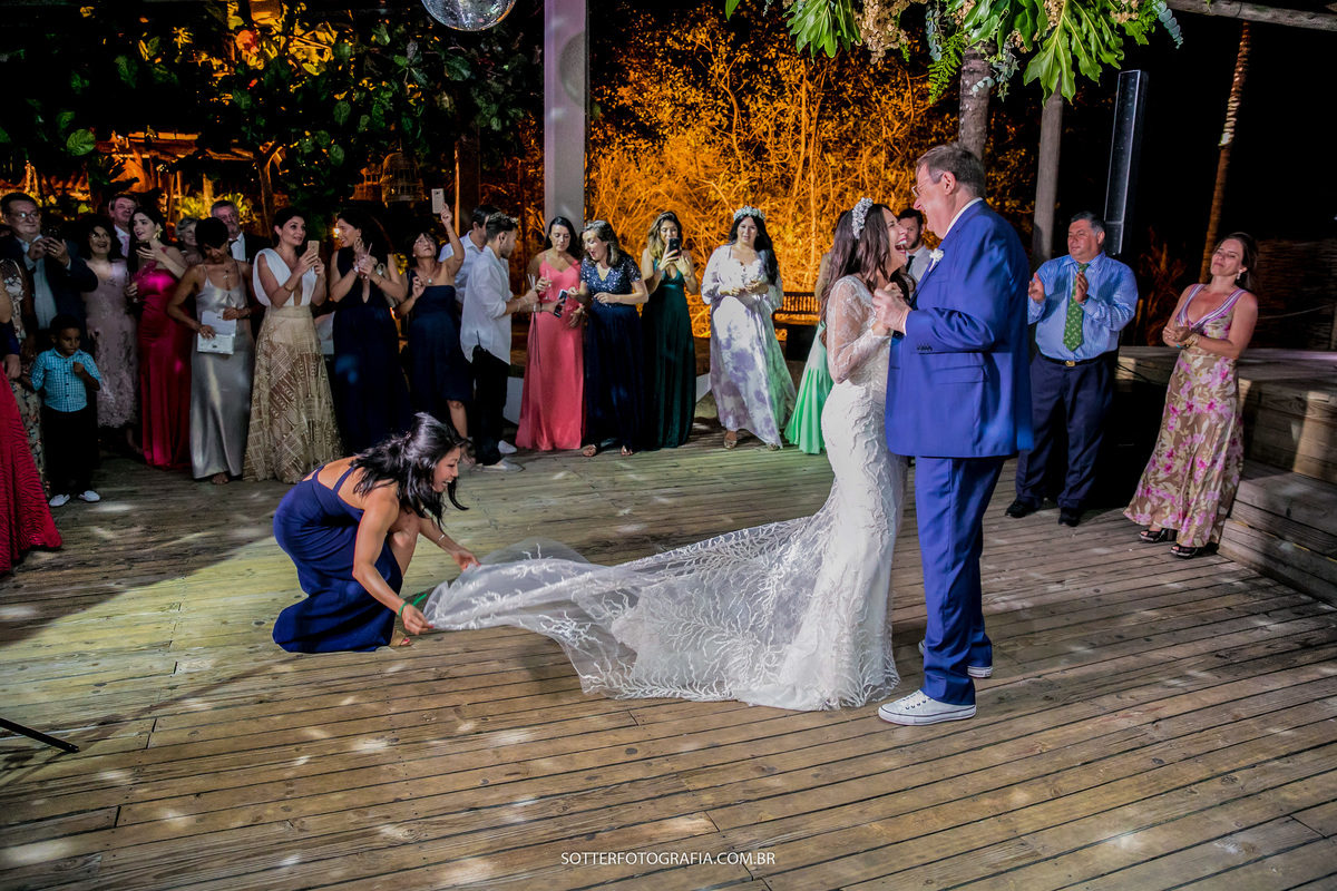 enquanto os noivos dançam uma amiga japonesa ajeita a calda do vestido da noiva e os convidados observam