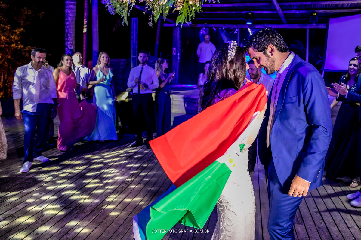 fotografo de casamento em trancoso sotter fotografia - na imagem os noivos dançam com a bandeira de marrocos, verde vermelha e branca 