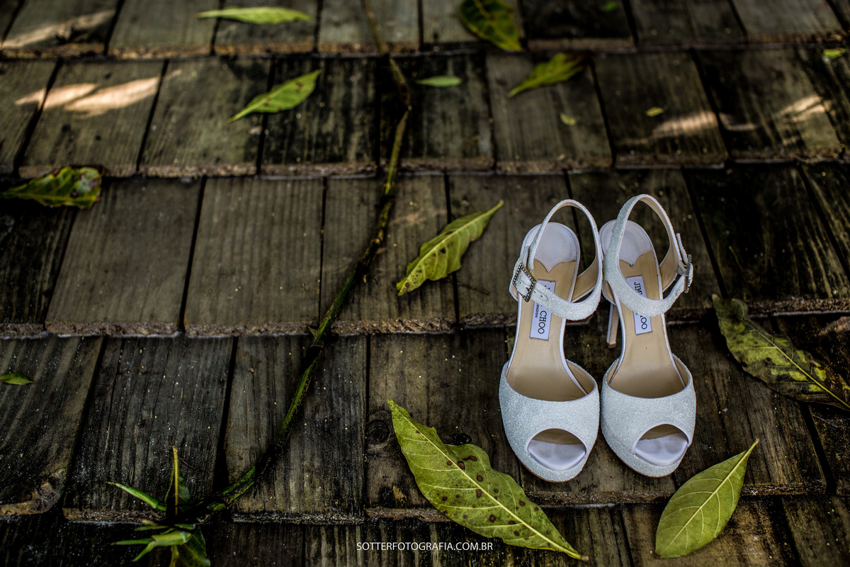 sapato da noiva junto com folhas e madeiras