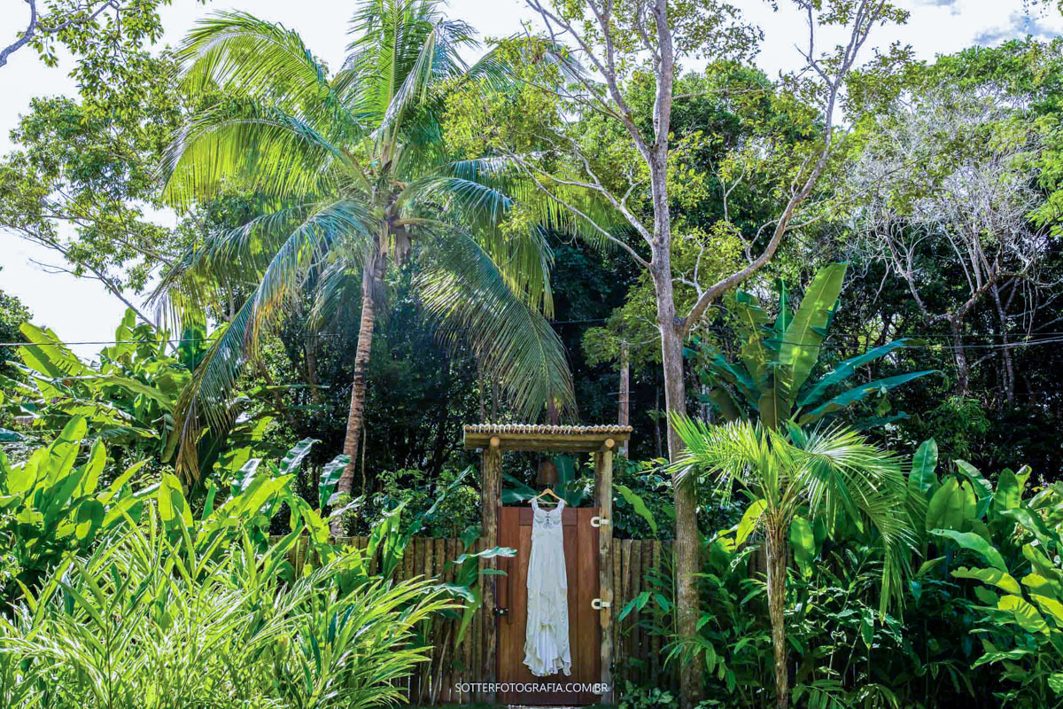 FOTOGRAFO DE CASAMENTO EM TRANCOSO pendurou o vestido na porta de madeira da casa da NOIVA