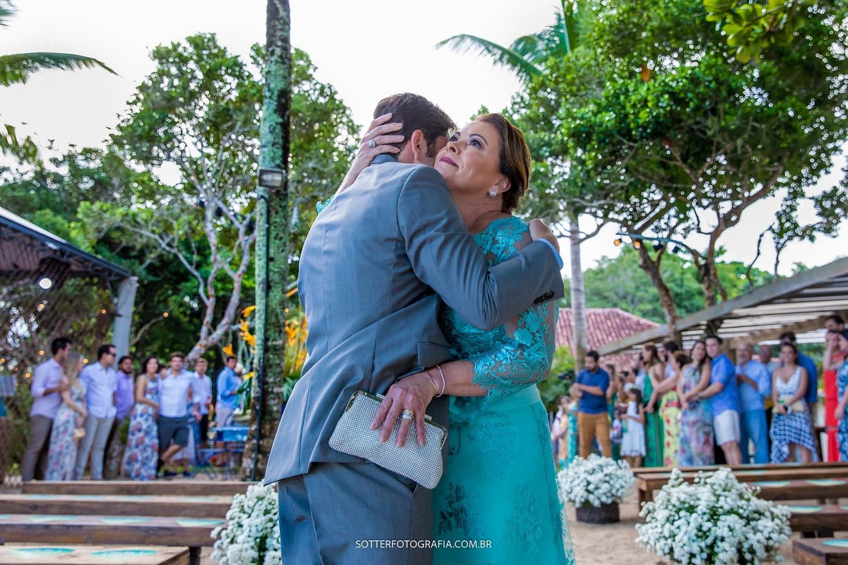 mãe beijando o filho na entrada da cerimonia 