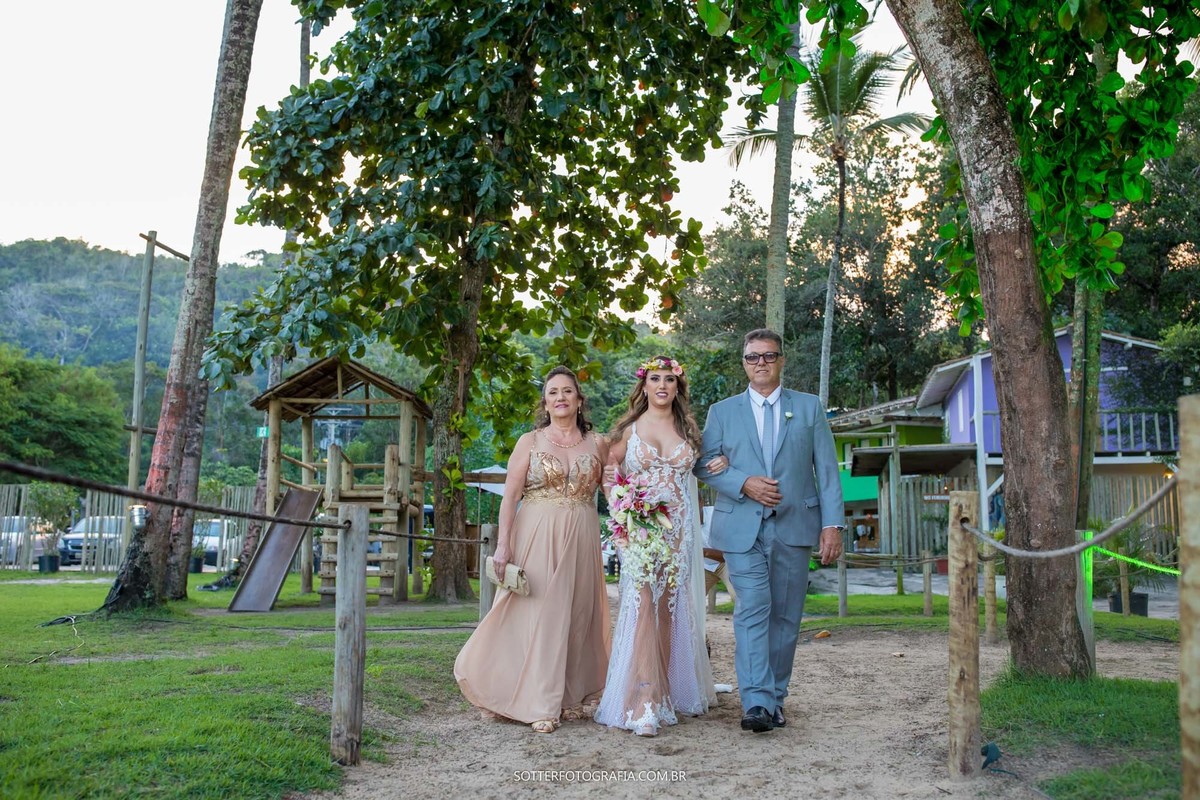  casamento na praia de arraial dajuda noiva sendo acompanhada ate o altar por seus pais sotter fotografia