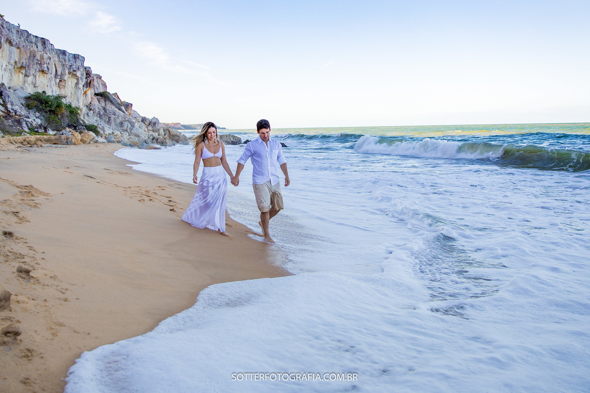 ensaio realizado em trancoso com noivos caminhando na praia com sotter fotografia fotografo de casamento