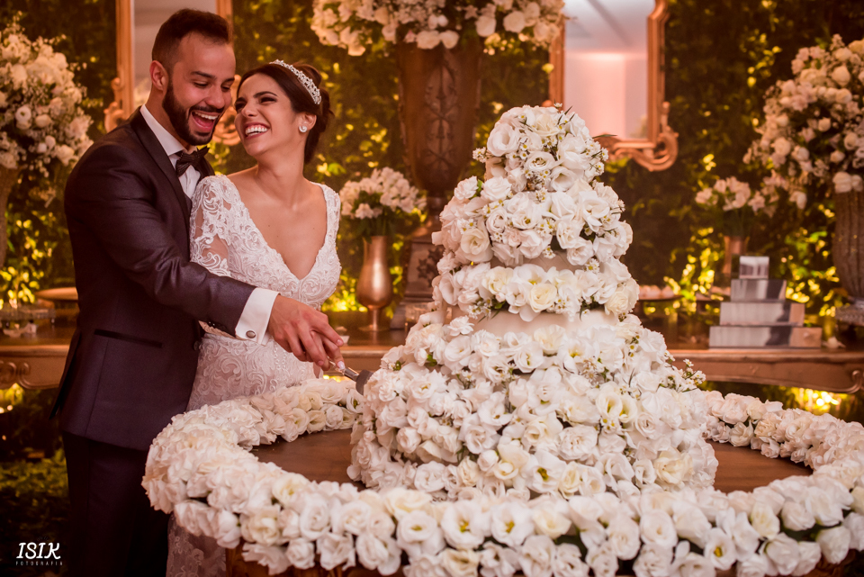 noivos na mesa do bolo fotografia de casamento