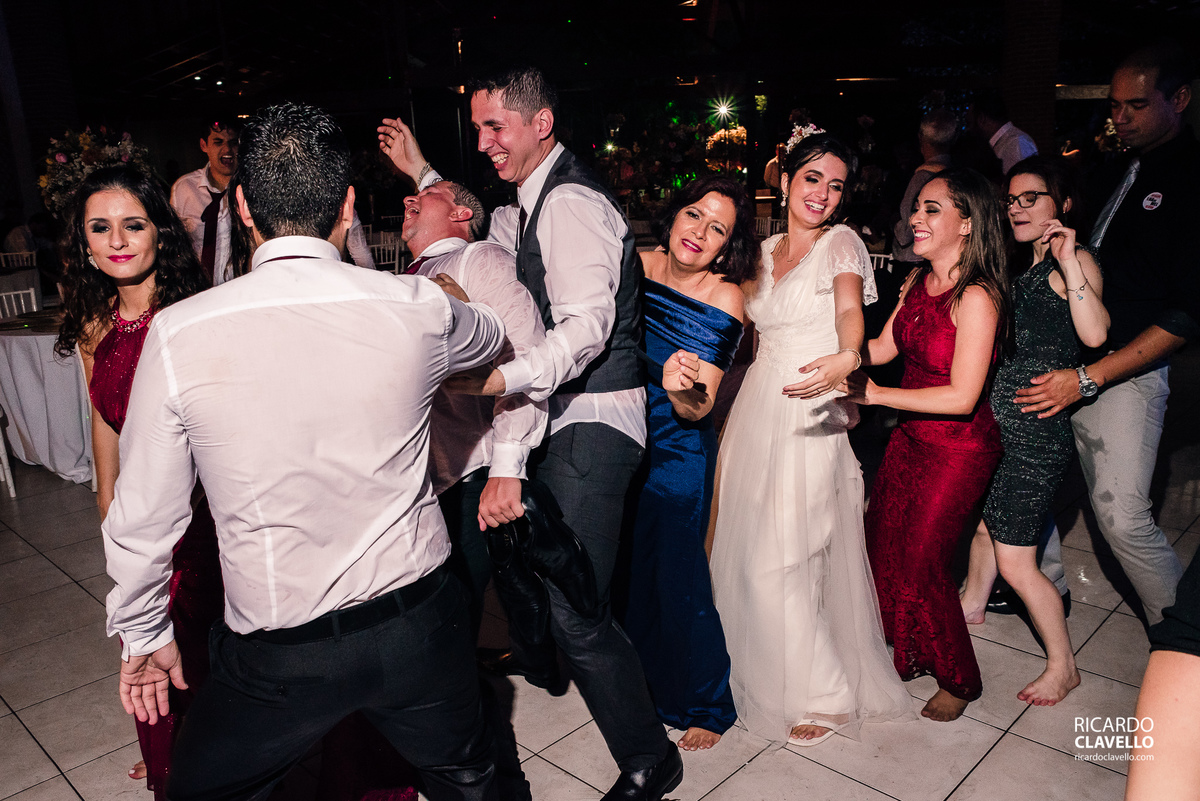 noivos e convidados fazendo uma fila na pista de dança - Fotografia de Casamento RJ - Fotografia de Casamento Niterói - Fotógrafo de Casamento RJ - Fotografia de Casamento JF - Fotografo Casamento - Melhores fotos de casamento