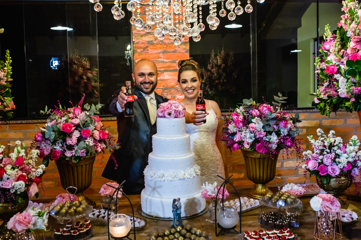 Noivos Camila e Glauber brindando com coca cola em seu casamento no espaço Vista verde