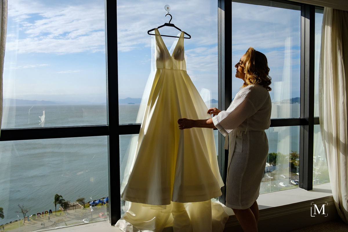 mãe da noiva olhando para o vestido 