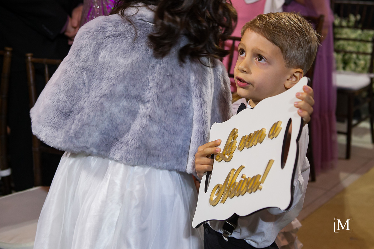 pajem segurando placa lá vem a noiva