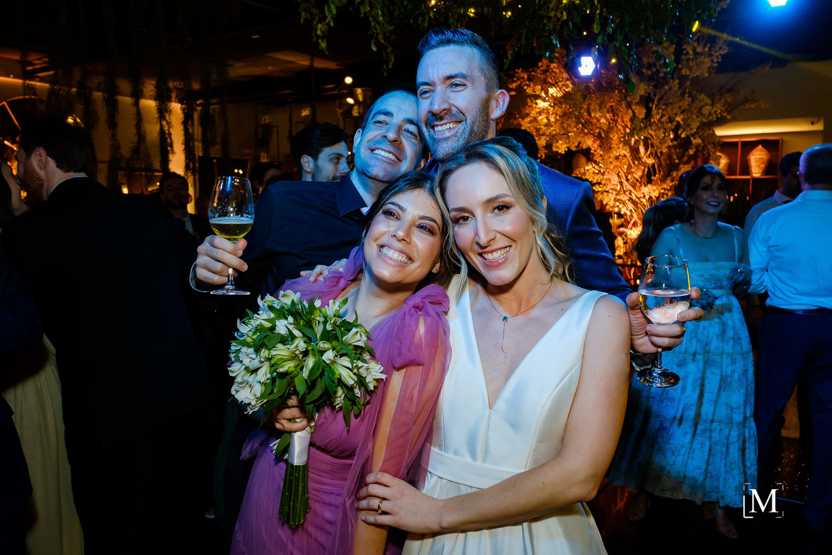 retrato dos noivos com convidada que pegou o buquê