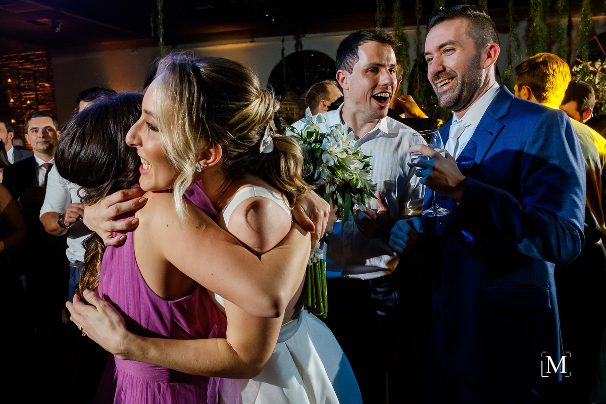 noiva abraçando amiga na pista de dança