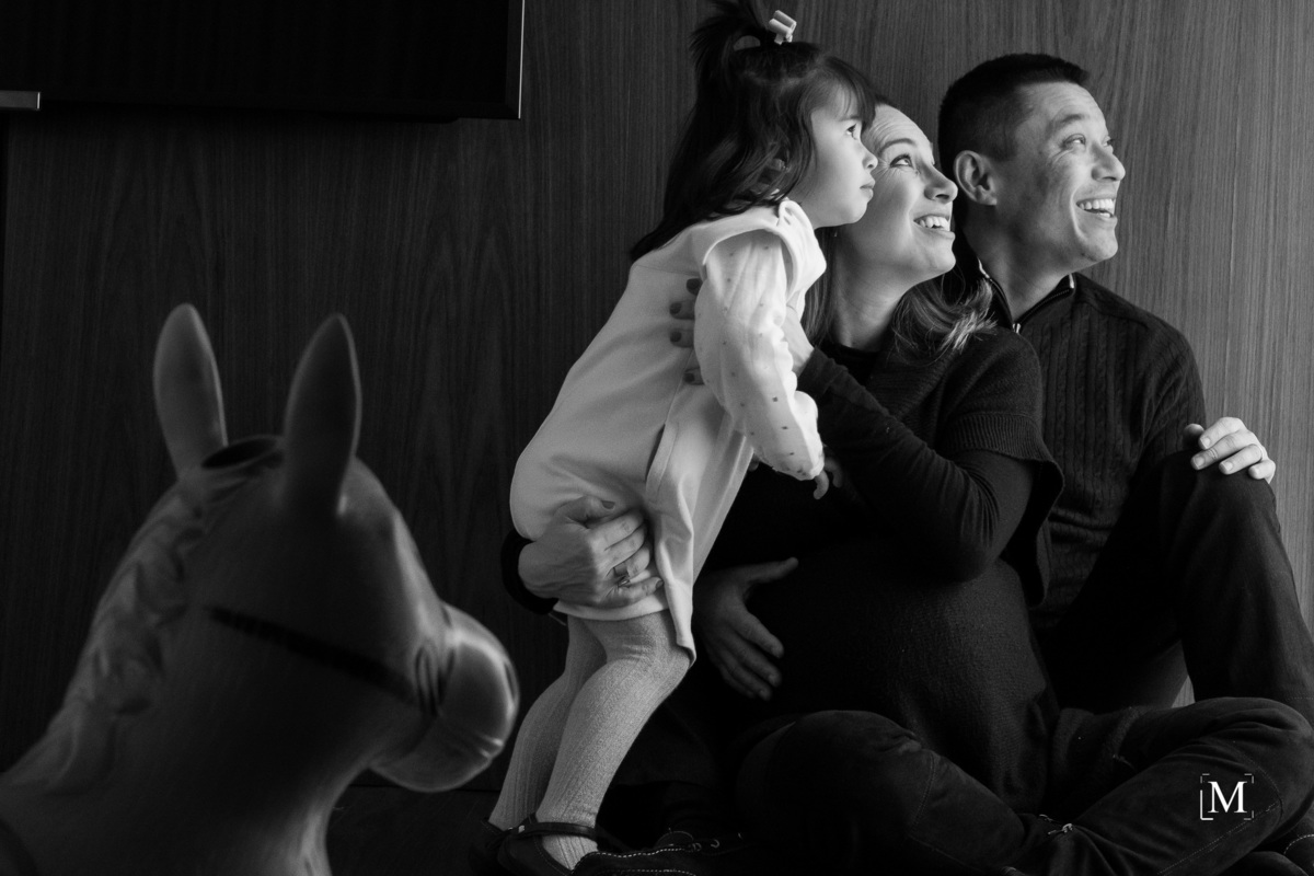 menina e seus pais olhando pela janela