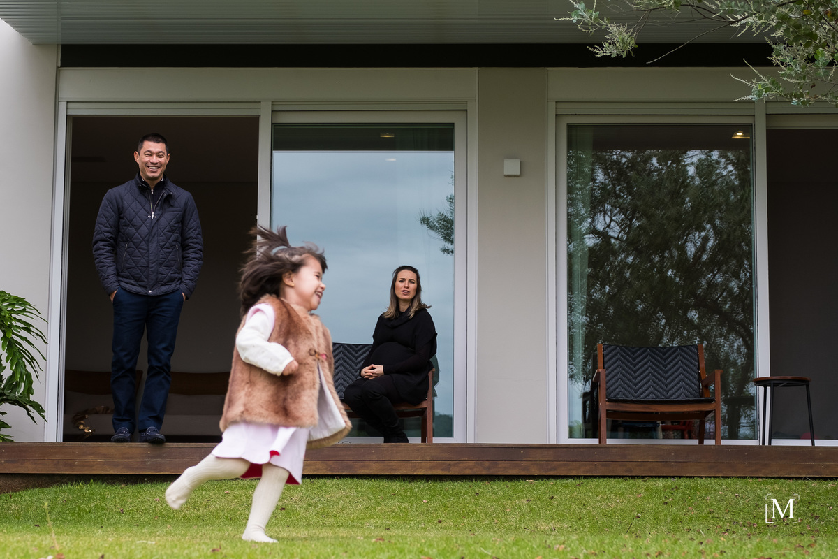 menina correndo pelo quintal da casa