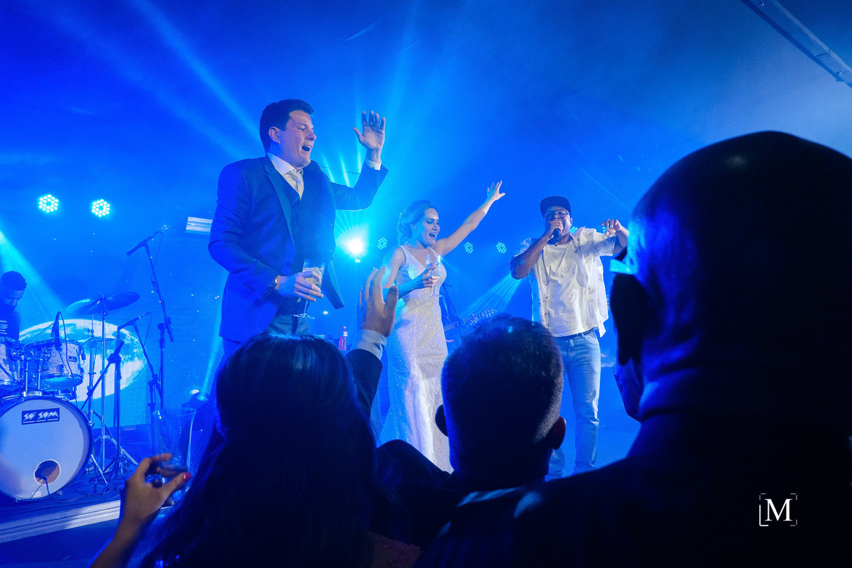 noivos no palco junto com o cantor Buchecha