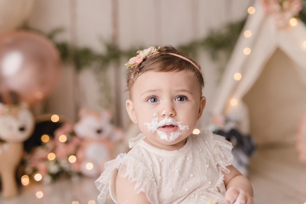 ensaio smash the cake bosque encantado cabaninha bichinhos floresta bebe infantil primeiro aninho bolo no cenário balões 1 ano plantinhas flores comendo bolo lambuzada chantilly