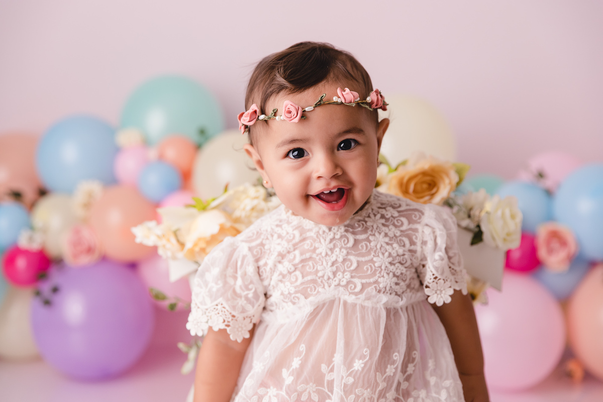 ensaio smash the cake jardim encantado bebe infantil primeiro aninho cadeirinha balões coloridos flores sorrindo