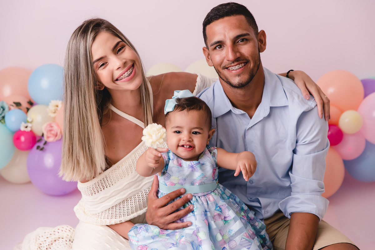 ensaio smash the cake jardim encantado bebe infantil primeiro aninho cadeirinha balões coloridos flores com os pais segurando flor