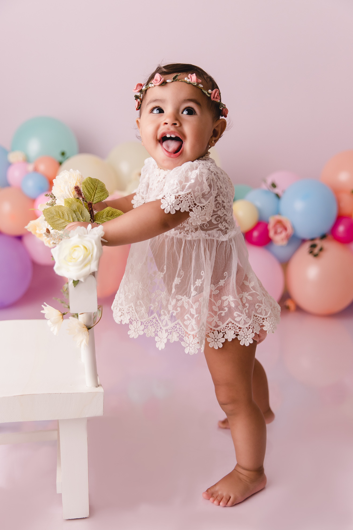 ensaio smash the cake jardim encantado bebe infantil primeiro aninho cadeirinha balões coloridos flores sorrindo roupinha renda e tiara de flores