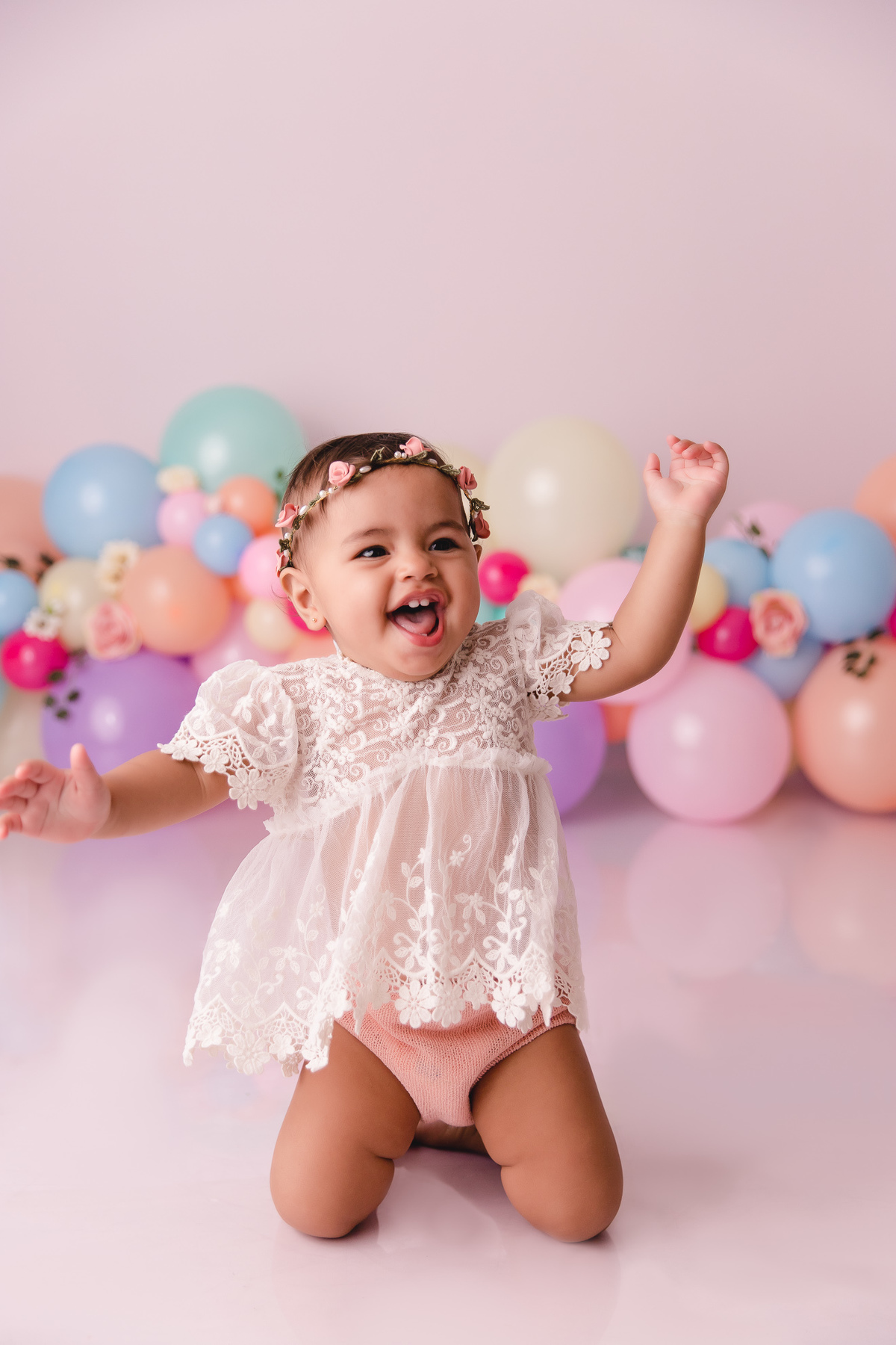 ensaio smash the cake jardim encantado bebe infantil primeiro aninho cadeirinha balões coloridos flores sorrindo roupinha renda e tiara de flores