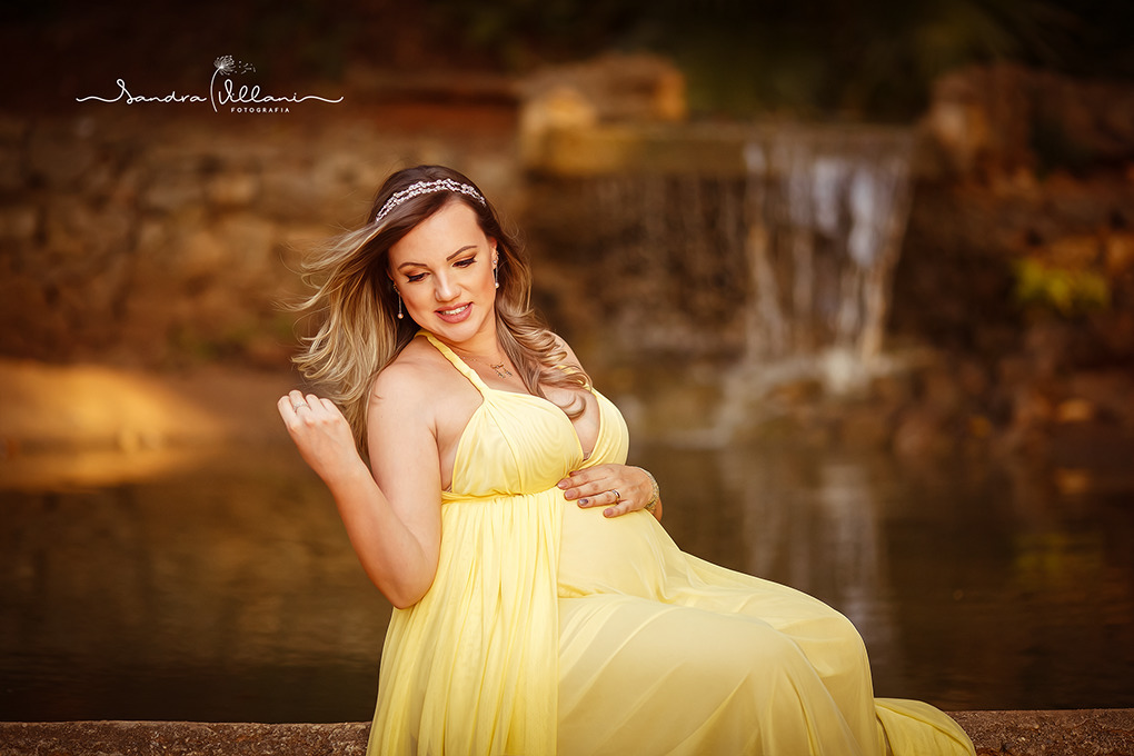 ensaio book gestante realizado em São Caetano do Sul SP gravida está com cabelos esvoaçantes em frente a uma queda de água