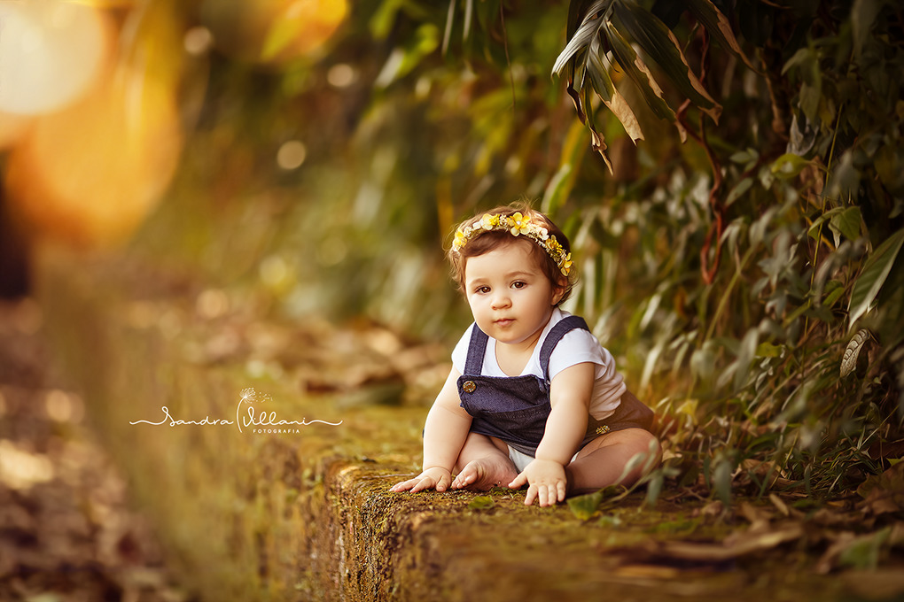 ensaio infantil - mãe e filha - família com a Sara sentadinha no muro com muito verde