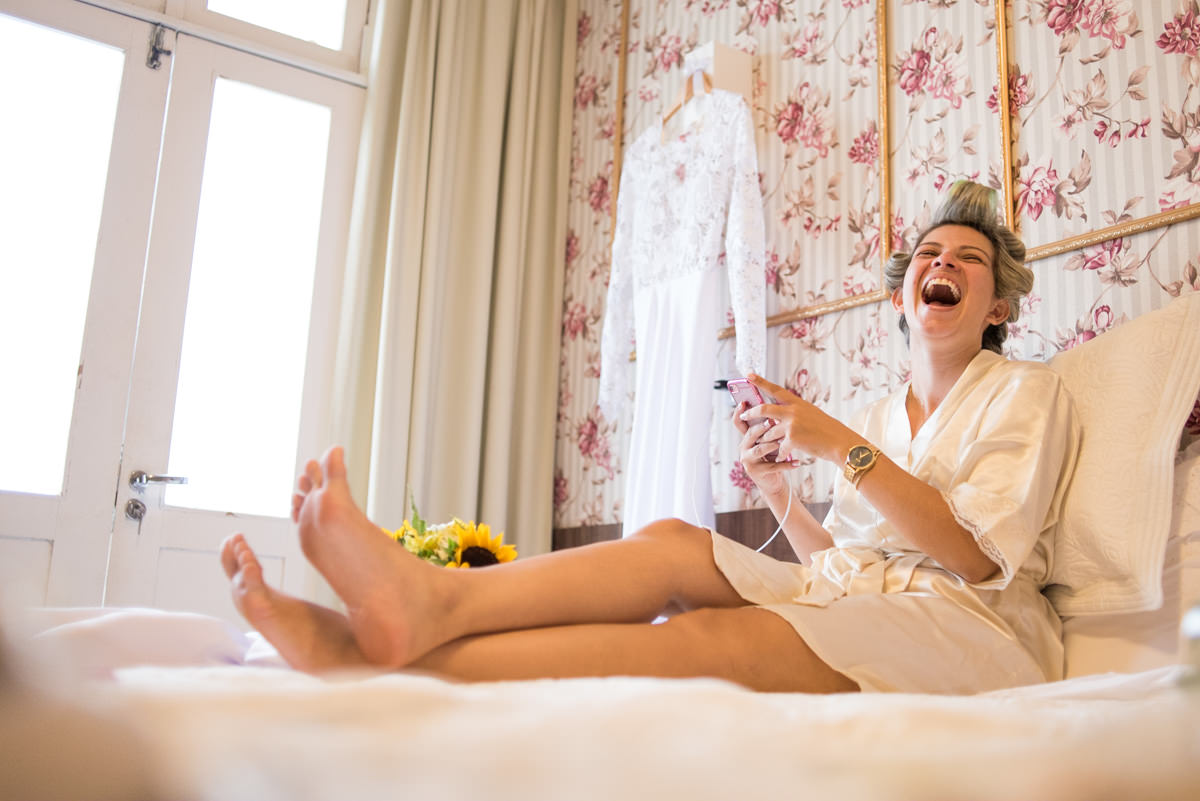 Noiva no celular no casamento de Karol e Andre, na pousada Macamirim em Natal RN.