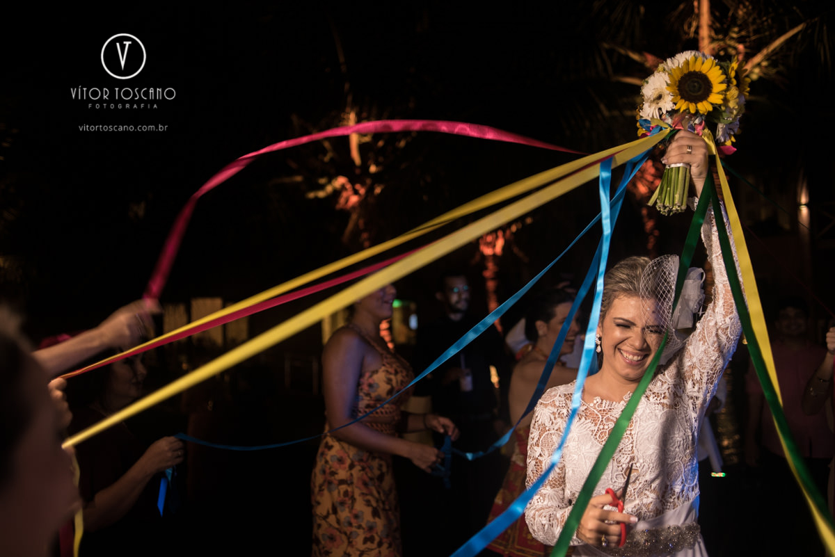 Noiva cortando as fitas do buque Sessão dos noivos no casamento de Karol e Andre, na pousada Macamirim em Natal RN.