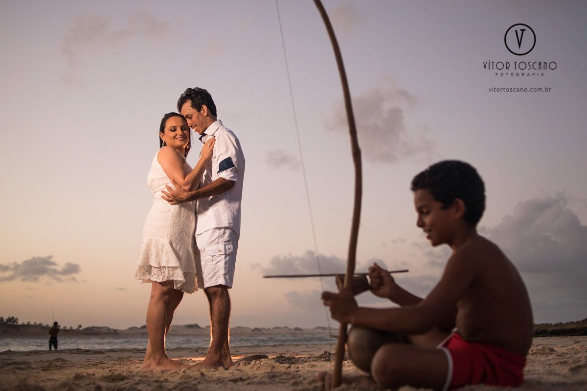 noivo e noiva abraçados e menino tocando berimbau no ensaio pre wedding de monick e jhonatan