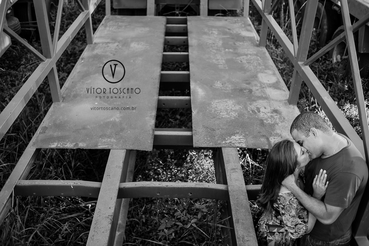 Casal namorando entre as ferragens durante o ensaio fotográfico de Jucielly e Auderi, em Natal-RN.