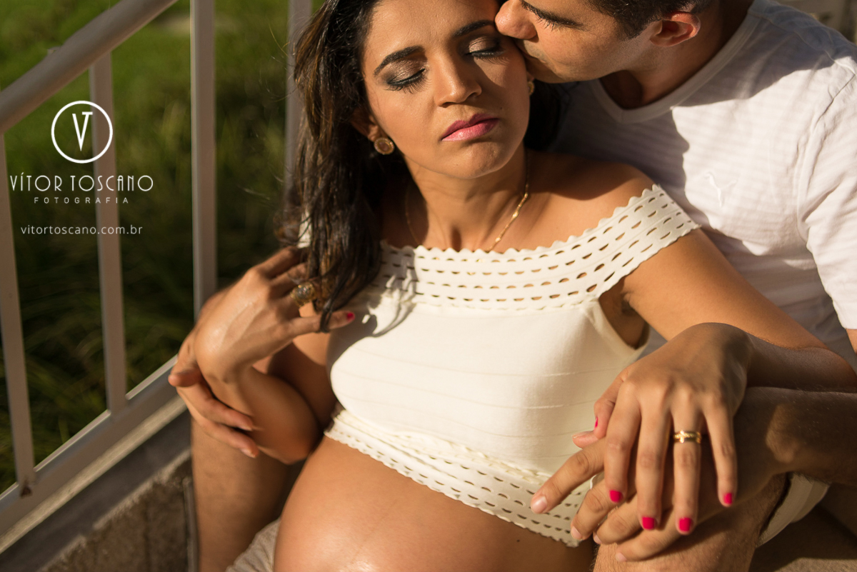 Beijo do pai no canto do olho da gestante durante o ensaio fotográfico da Gestante Marta, em Natal-RN.