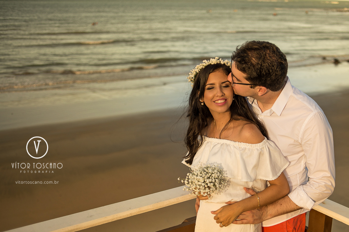 Beijo do noivo na noiva segurando um buquê durante o ensaio fotográfico do casal Rafael e Andreza, em Natal-RN.