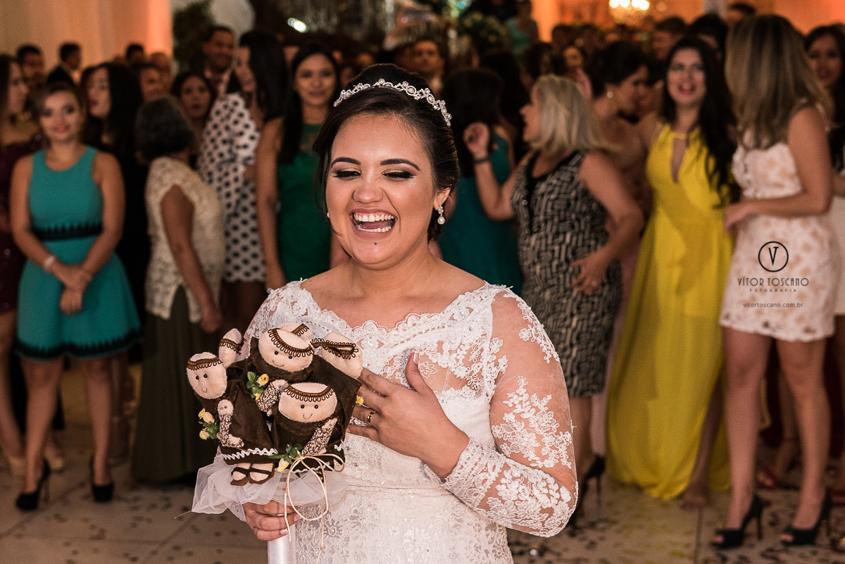 Noiva rindo com o buque de santo antonio na mão no casamento de Flavia e Tulio, em Natal-RN.