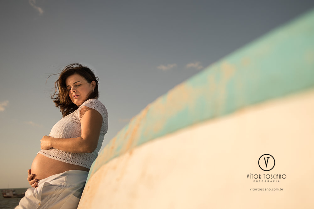 Gestante daniela encostada no barco no  ensaio de gestante, em São Miguel do Gostoso-RN.