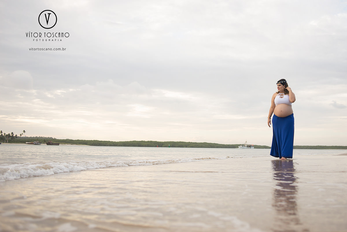 Mãe caminhando à beira mar no ensaio de gestante, em Natal-RN na praia do y.
