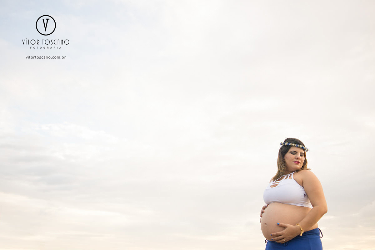 Mãe com a mão na barriga no ensaio de gestante, em Natal-RN na praia do y.
