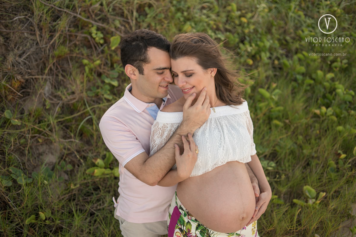 Marido pegando delicadamente o rosto da esposa no ensaio de gestante de Ana Flora em Natal-RN.