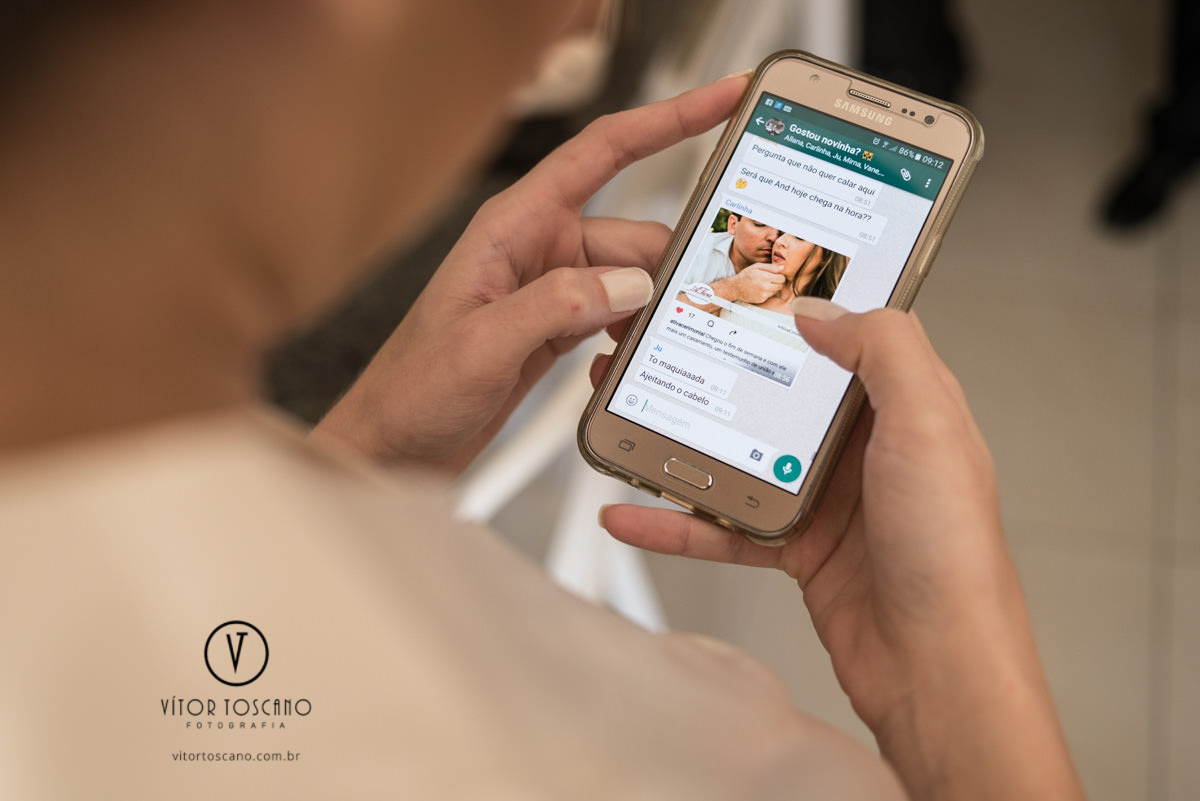 Noiva olhando o whatsapp no casamento de Andreza e Thales, em Natal-RN.