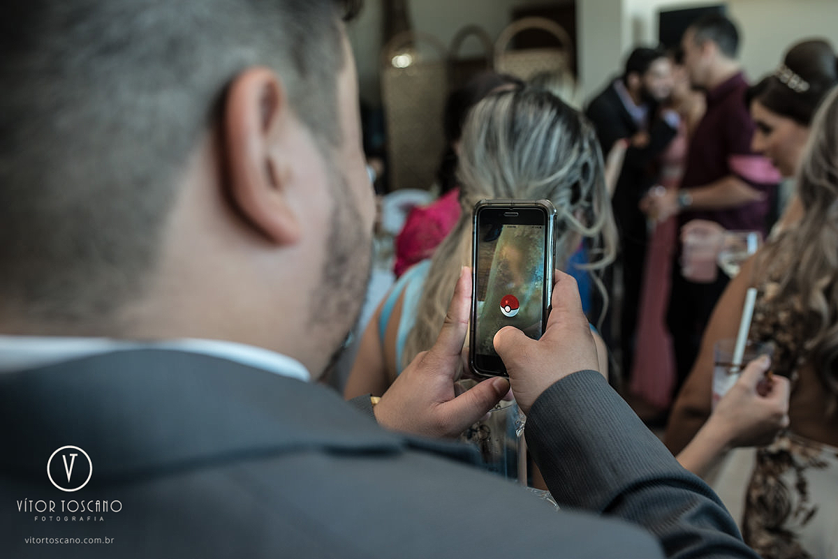 Convidado caçando pokemon no casamento de Andreza e Thales, em Natal-RN.