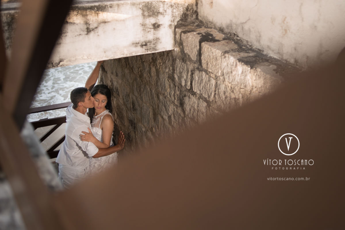 Casal namorando na escada no  ensaio de Ana Paula e André, na praia de Pirangi em Natal-RN.