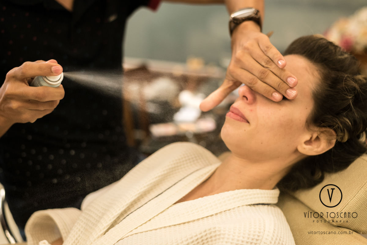 Noiva se maquiando no casamento de Tanísia e Felipe, em Natal-RN.