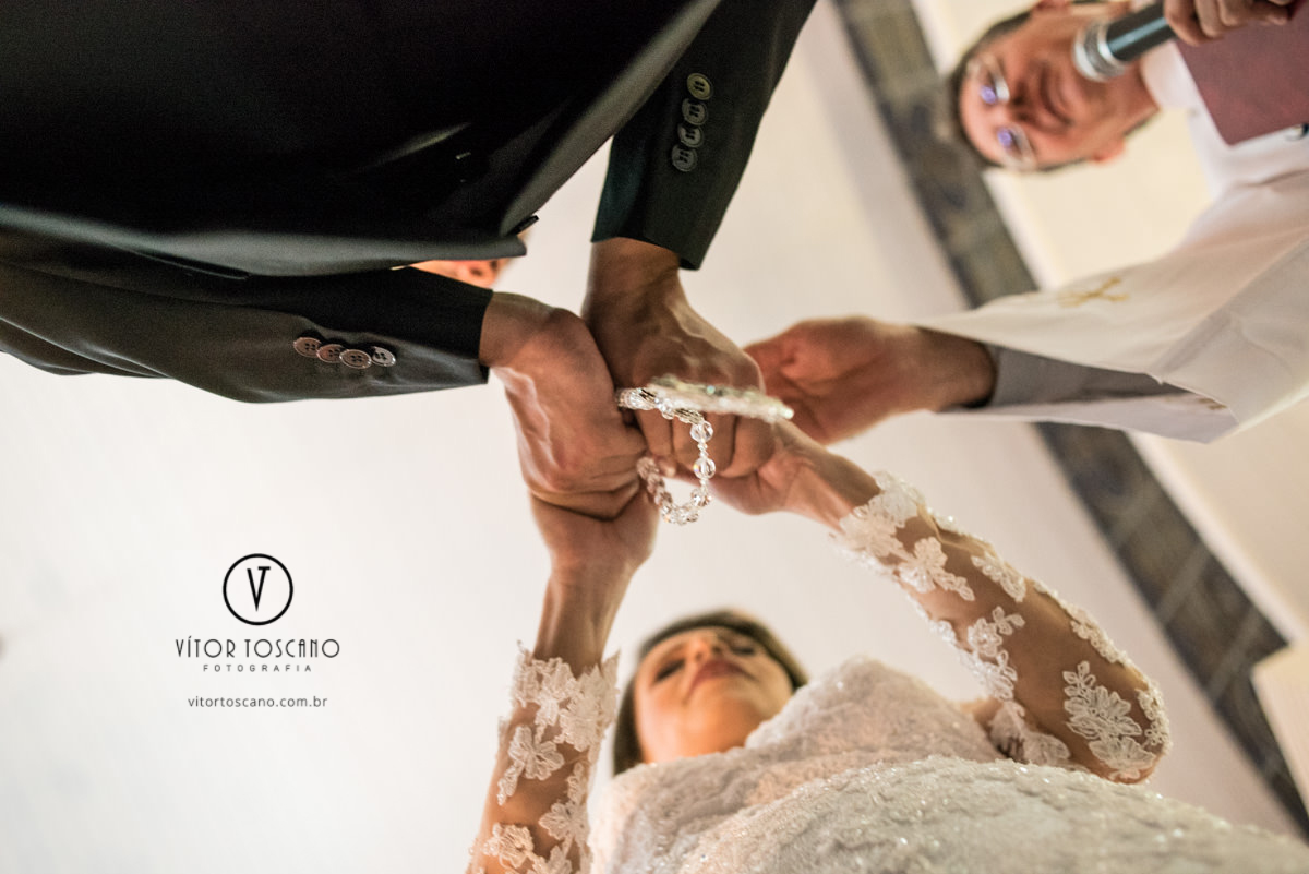 Padre abençoando as alianças no casamento de Tanísia e Felipe, em Natal-RN.