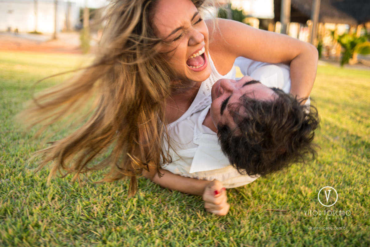 Casal rolando no chão no Ensaio de casal de Marília e Jornandis, em Punaú-RN.